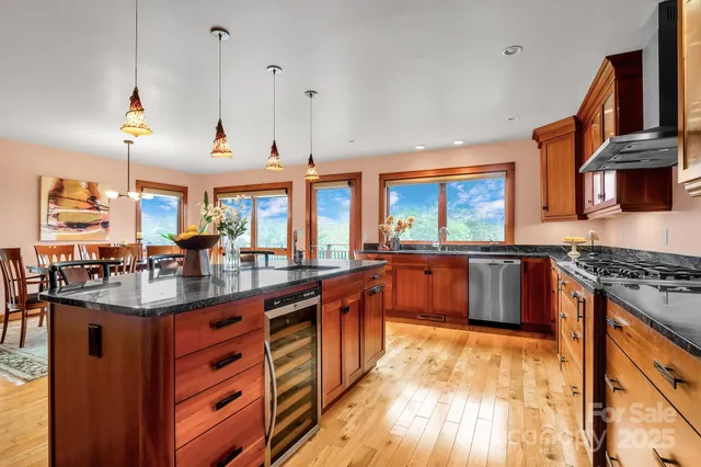 a large kitchen with stainless steel appliances granite countertop a stove and large cabinets
