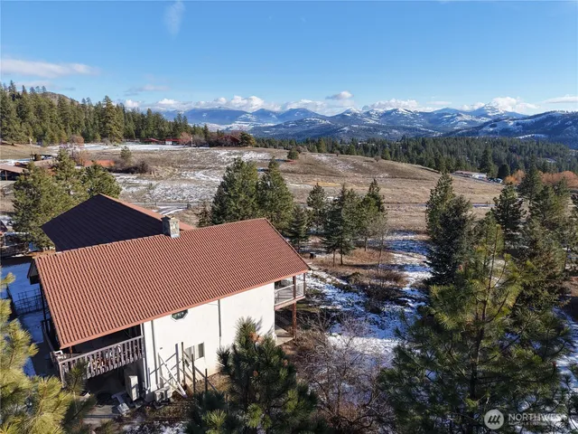 a view of a house with a yard and mountain view in back