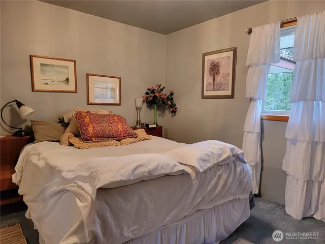 a bedroom with a bed and a painting on the wall