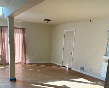 a view of a room with wooden floor