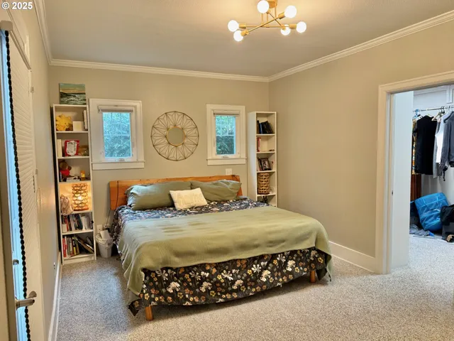 a bedroom with a bed mirror and lamp