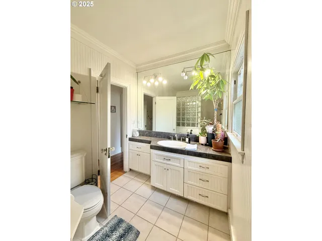 a bathroom with a double vanity sink toilet and a mirror