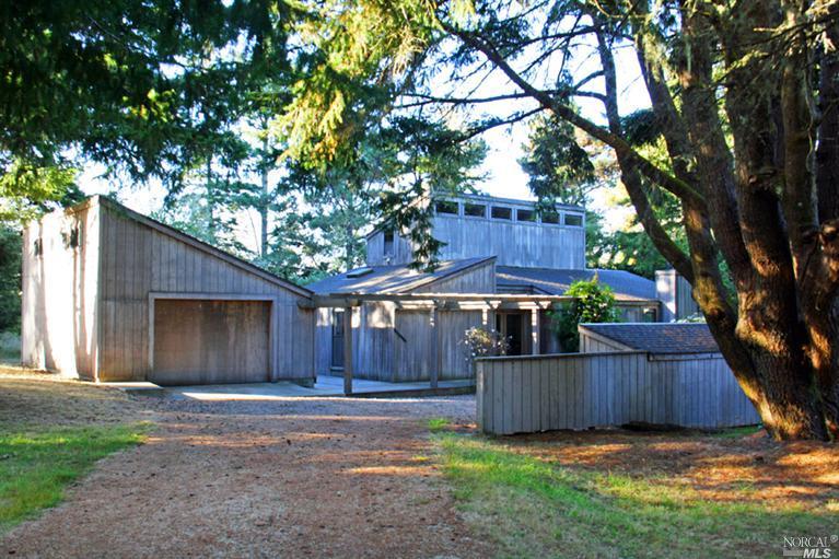 a view of a house with a yard and wooden fence