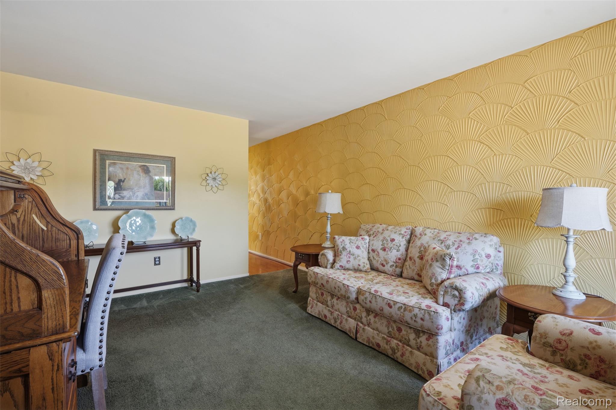 18160 Raleigh Square Drive Southgate, MI 48195 - Photo 6 of 31 Accent wall featuring a raised fan pattern, plush green carpeting, and a light-toned wall finish