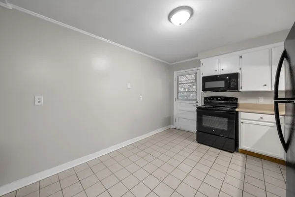 a kitchen with granite countertop a refrigerator and a stove top oven