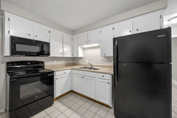 a kitchen with a refrigerator stove and white cabinets