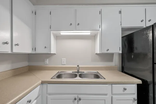 a kitchen with white cabinets and a sink