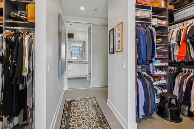 a view of walk in closet with clothes and shoes