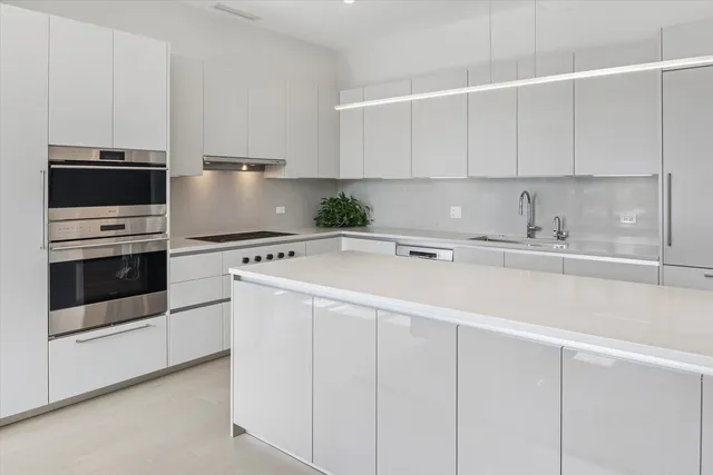 a kitchen with appliances a sink and cabinets