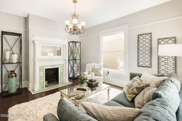 a living room with furniture a chandelier and a fireplace