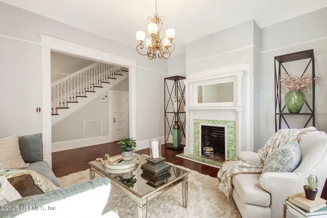 a living room with furniture a fireplace and a chandelier