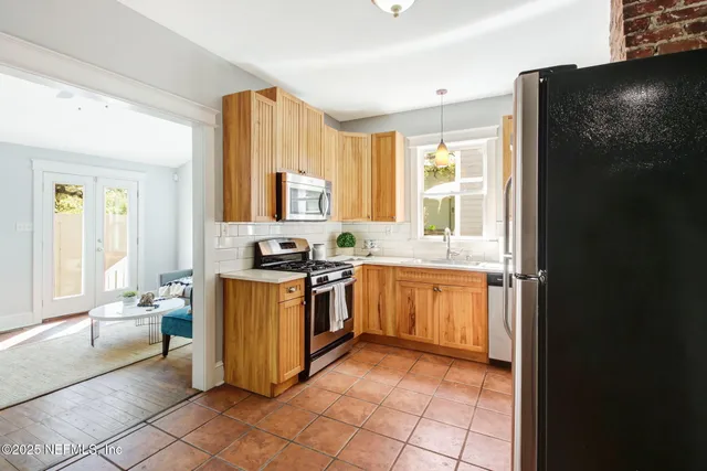 a kitchen with stainless steel appliances granite countertop a stove a sink and a refrigerator