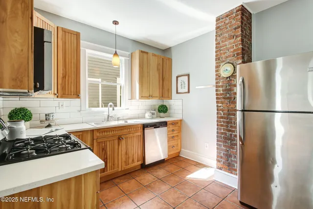 a kitchen with stainless steel appliances a stove a refrigerator and a sink