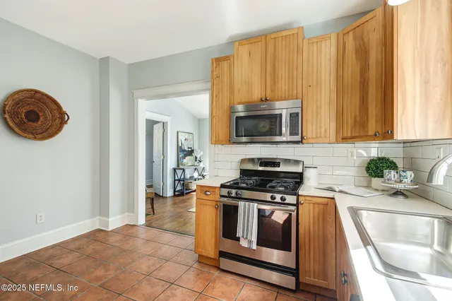 a kitchen with a stove a microwave and sink