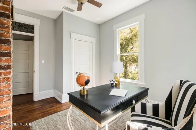 a view of a workspace with furniture and window