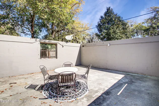 a view of a chair and table in the backyard