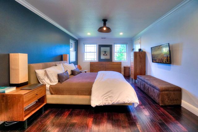 a bedroom with a bed and wooden floor