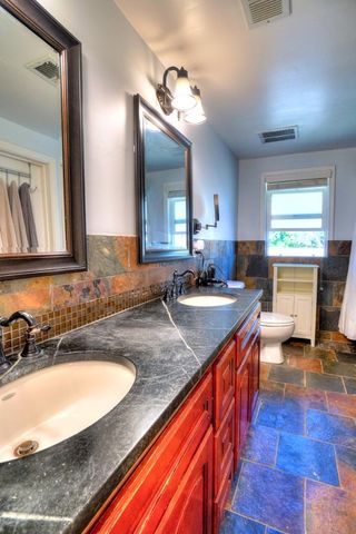 a bathroom with a granite countertop sink and a large mirror