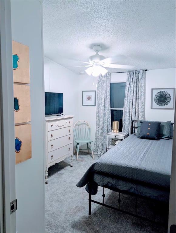 1075 1st Street Hawley, TX 79525 - Photo 17 of 20 a bedroom with a bed dresser and a flat tv screen