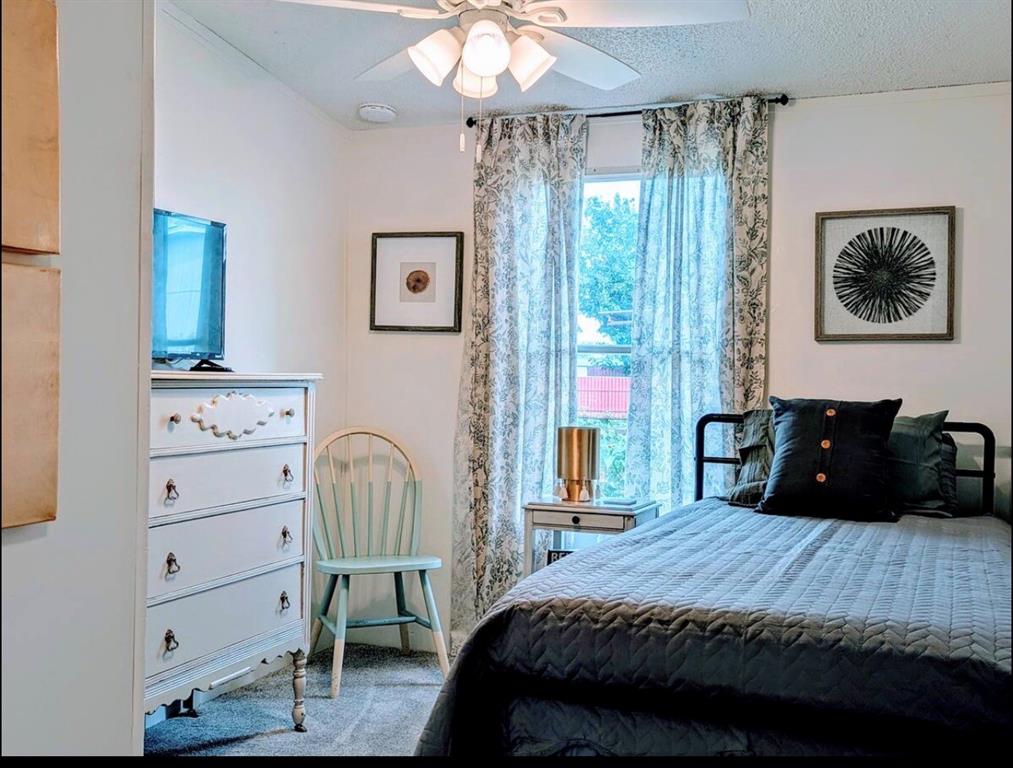 1075 1st Street Hawley, TX 79525 - Photo 18 of 20 a bedroom with a bed and a chandelier