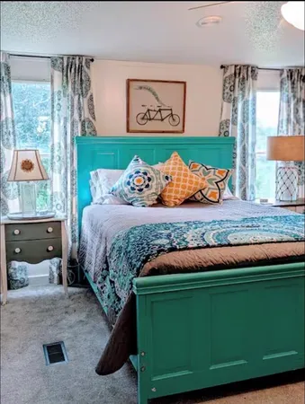 a bed sitting in a bedroom next to a window