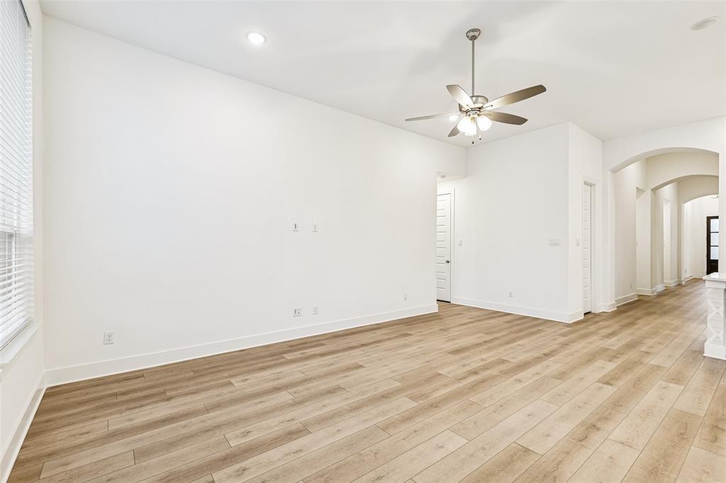 1144 Saddle Ridge Drive Aubrey, TX 76227 - Photo 11 of 34 an empty room with wooden floor fan and windows