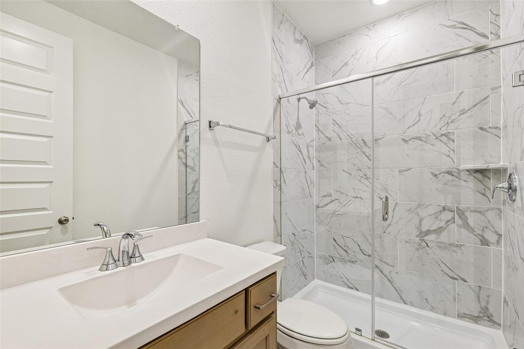 1144 Saddle Ridge Drive Aubrey, TX 76227 - Photo 21 of 34 a bathroom with a sink toilet and shower