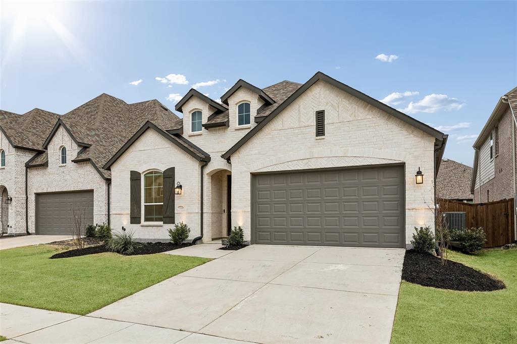 1144 Saddle Ridge Drive Aubrey, TX 76227 - Photo 33 of 34 a front view of a house with a yard and garage