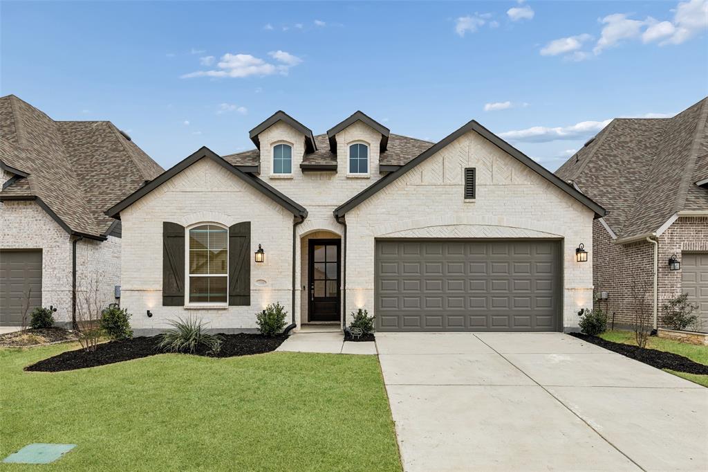 1144 Saddle Ridge Drive Aubrey, TX 76227 - Photo 34 of 34 a front view of a house with a yard and garage