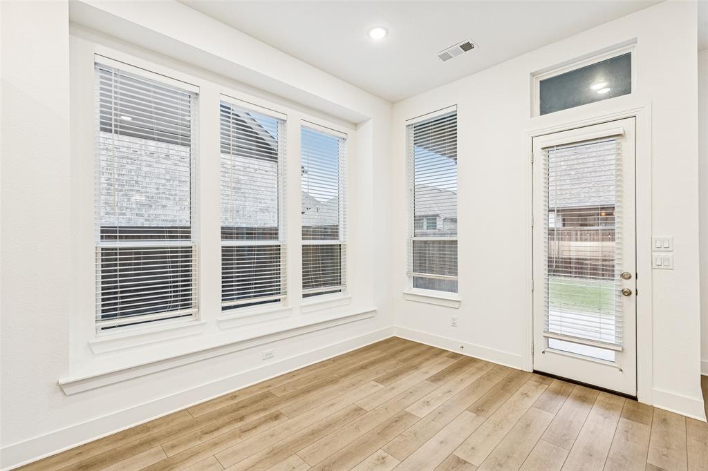 1144 Saddle Ridge Drive Aubrey, TX 76227 - Photo 10 of 34 a view of an empty room with wooden floor and windows