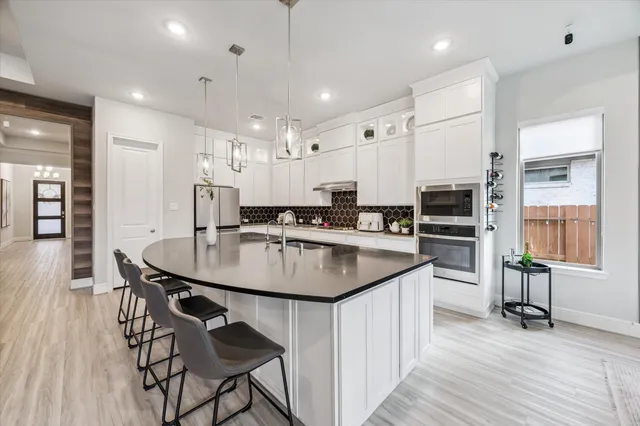 a kitchen with kitchen island a sink table and chairs