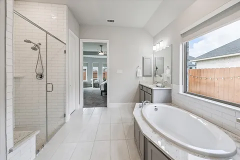 a large bathroom with a tub shower and sink