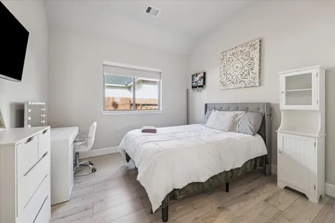 a bedroom with a bed and a flat screen tv