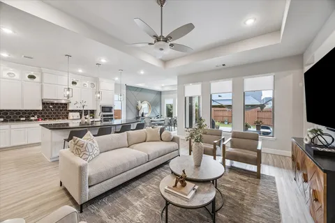 a living room with furniture kitchen view and a flat screen tv