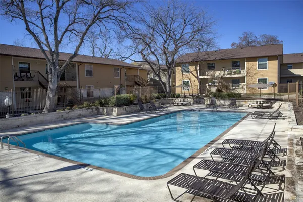 a view of a house with backyard water fountain and sitting area