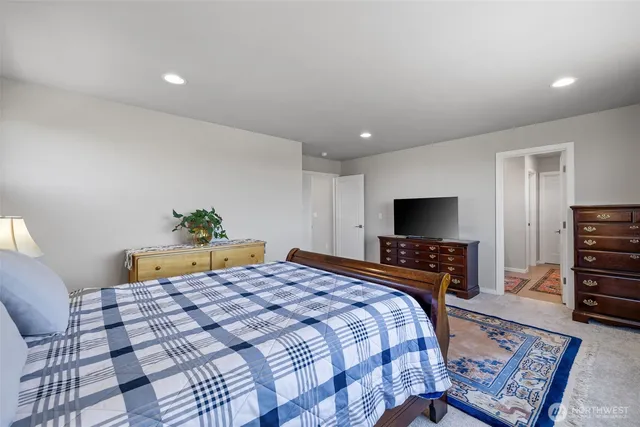 a bedroom with a bed a television and a couch