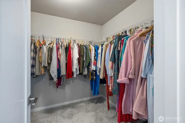 a view of walk in closet with clothes