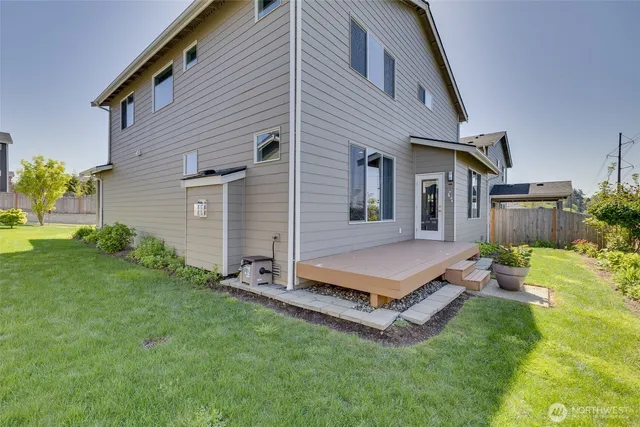 a white house with a small yard and a large tree