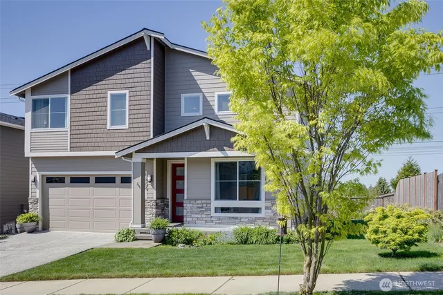 a front view of a house with a yard and potted plants