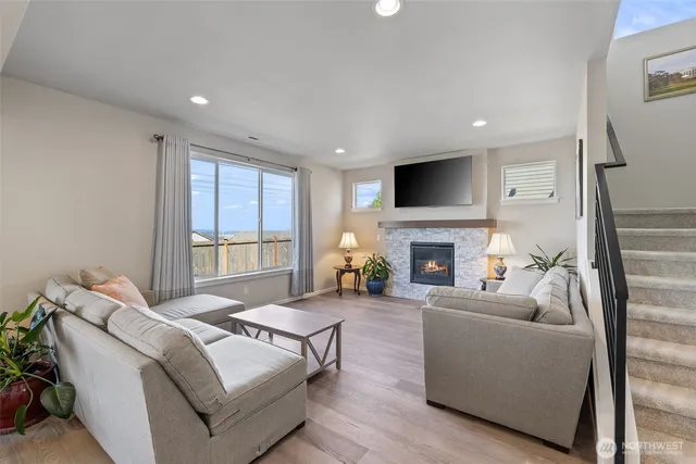 a living room with furniture a fireplace and a flat screen tv