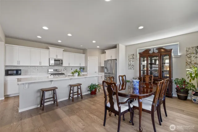 a kitchen with a dining table chairs and refrigerator