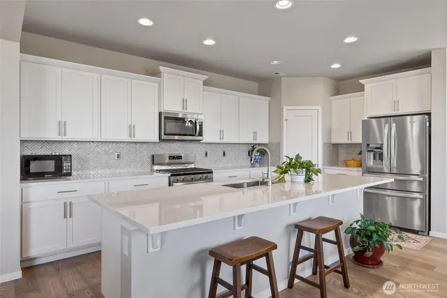 a kitchen with white cabinets and stainless steel appliances