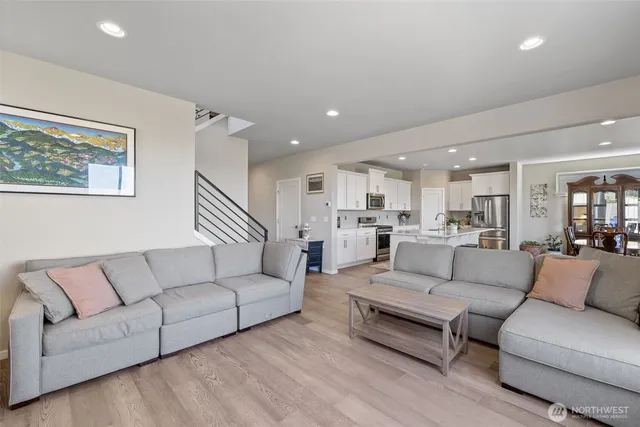 a living room with furniture and a view of kitchen