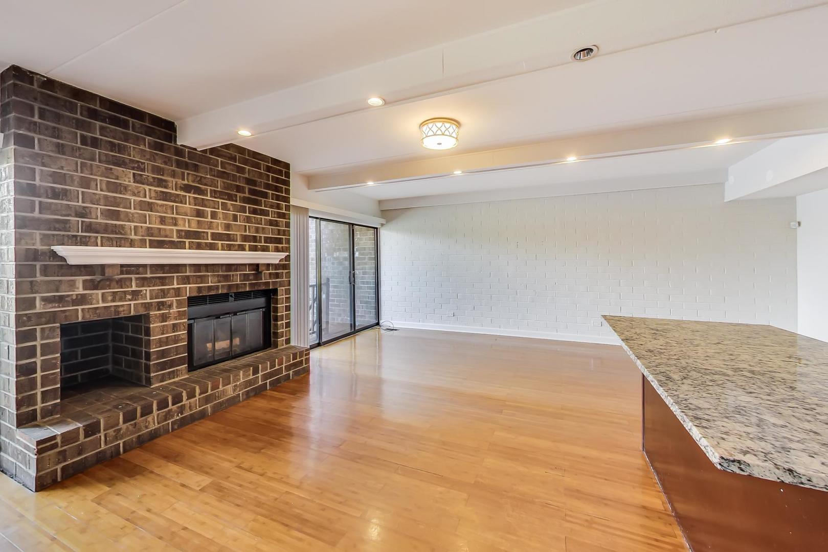 102 Kenneth Circle Elgin, IL 60120 - Photo 5 of 33 a view of an empty room with wooden floor fireplace and a window