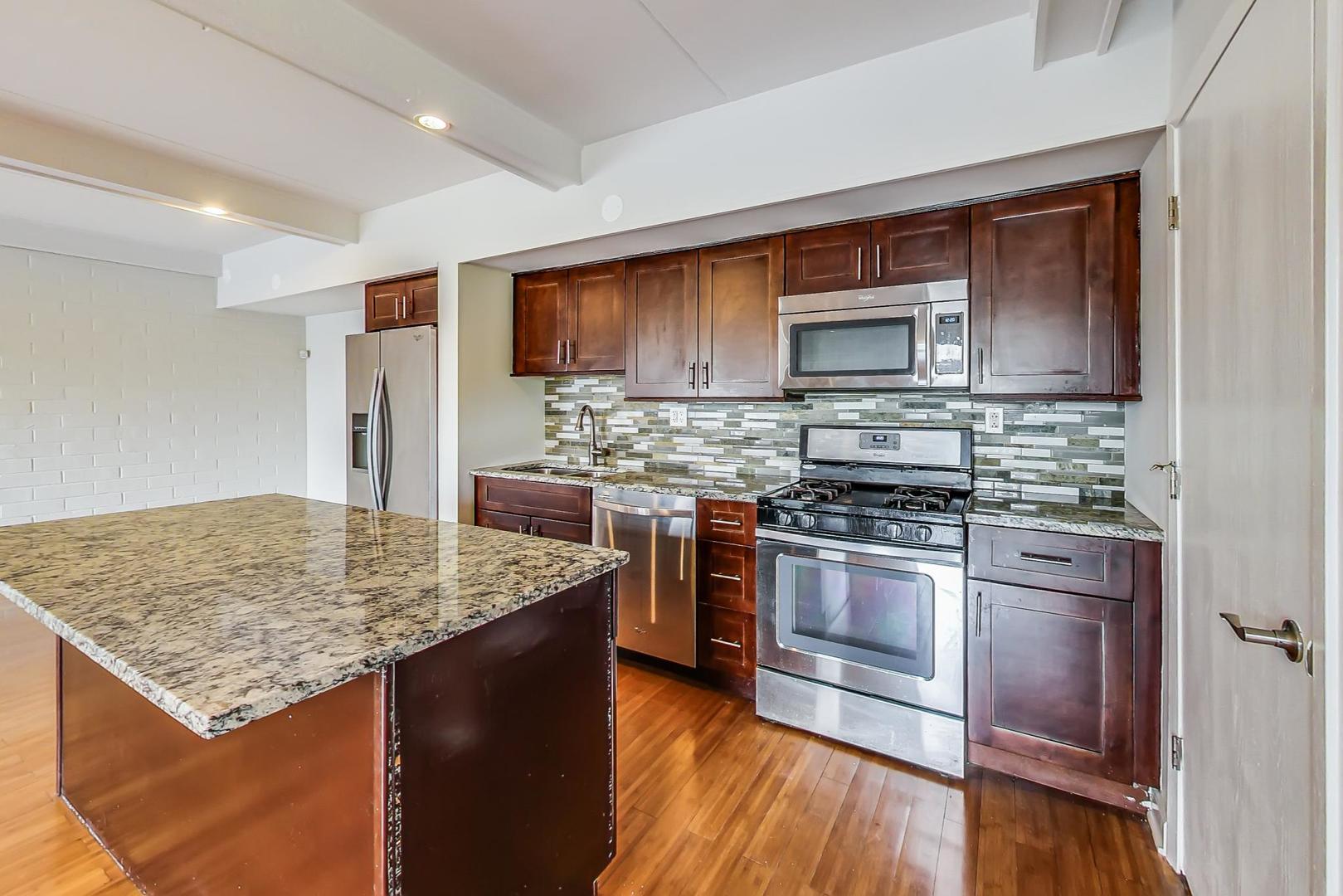 102 Kenneth Circle Elgin, IL 60120 - Photo 6 of 33 a kitchen with stainless steel appliances wooden floor sink stove and microwave