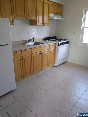 a kitchen with a sink a stove and cabinets
