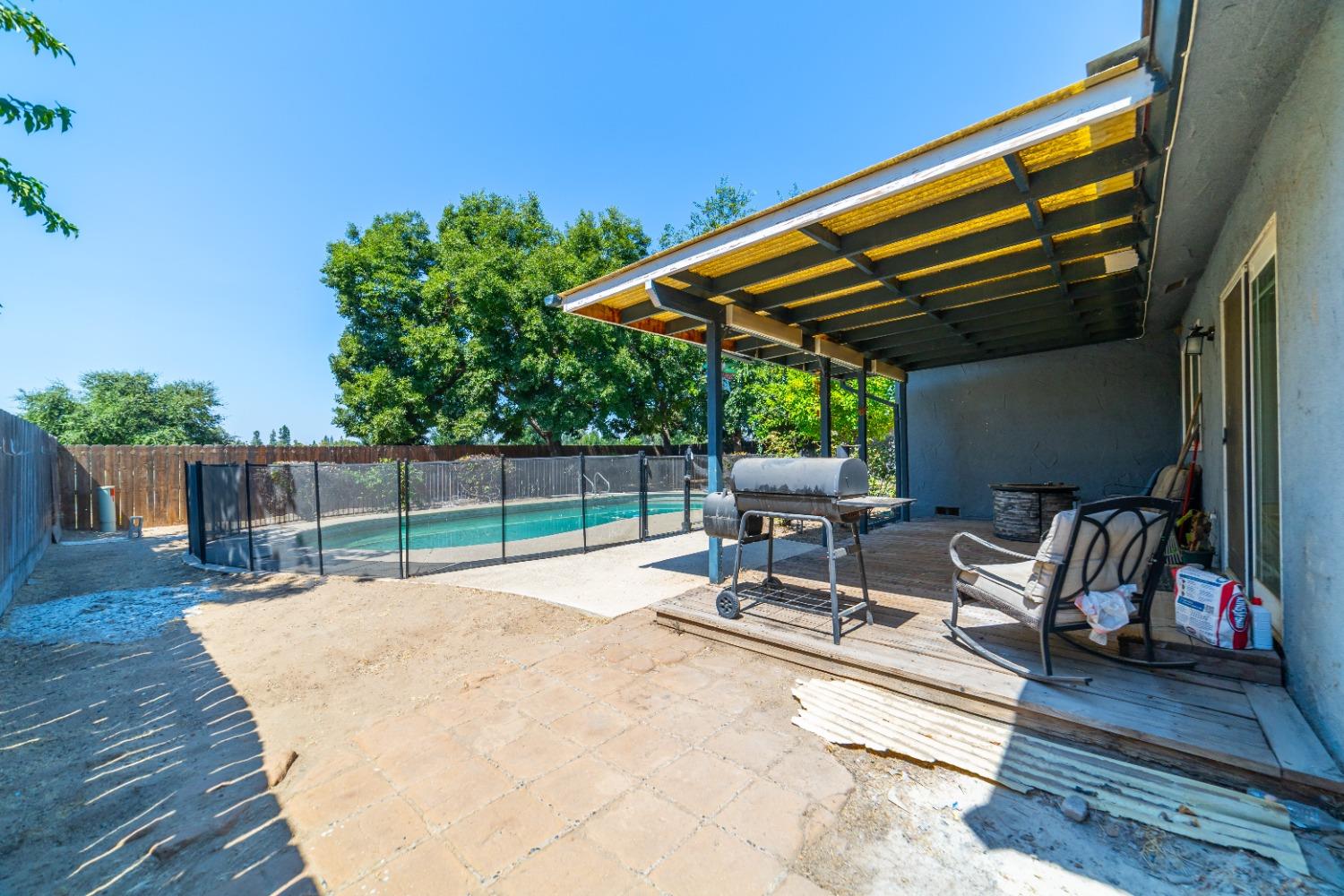 142 West Swift Avenue Clovis, CA 93612 - Photo 13 of 24 a view of backyard with a table and chairs under an umbrella