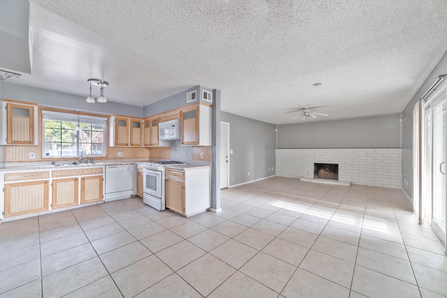 142 West Swift Avenue Clovis, CA 93612 - Photo 2 of 24 a large kitchen with a stove a sink dishwasher and a refrigerator