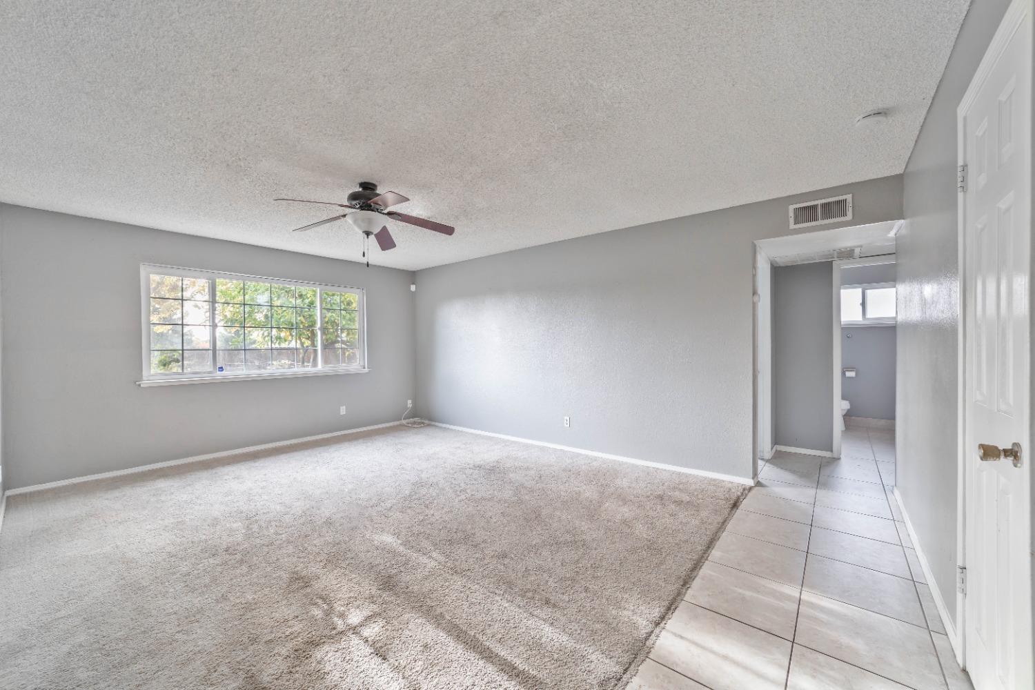 142 West Swift Avenue Clovis, CA 93612 - Photo 5 of 24 an empty room with windows and a ceiling fan