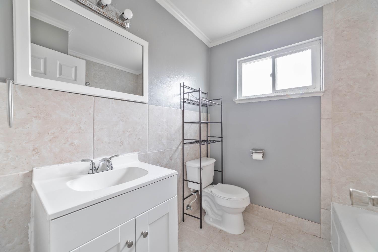 142 West Swift Avenue Clovis, CA 93612 - Photo 7 of 24 a bathroom with a toilet sink and a mirror